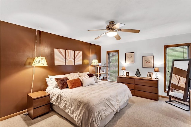 bedroom featuring light carpet, baseboards, and a ceiling fan