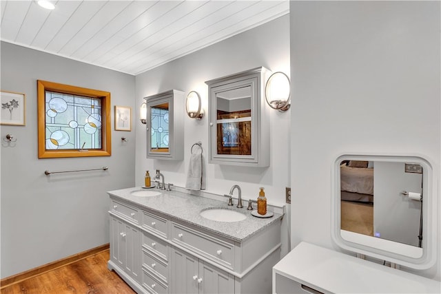 bathroom with wood ceiling, wood finished floors, double vanity, and a sink