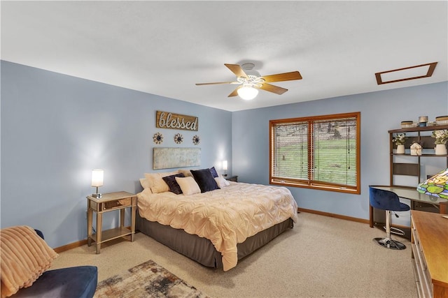 carpeted bedroom with baseboards, attic access, and ceiling fan