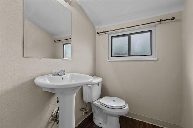 bathroom with toilet, wood finished floors, a sink, and baseboards