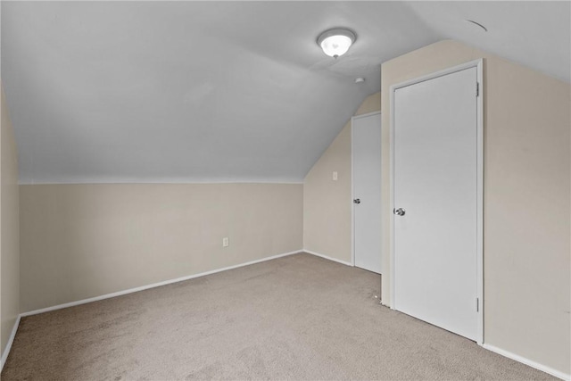 additional living space with carpet floors, baseboards, and vaulted ceiling