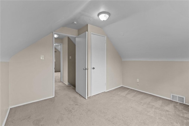 additional living space with carpet, visible vents, baseboards, and lofted ceiling