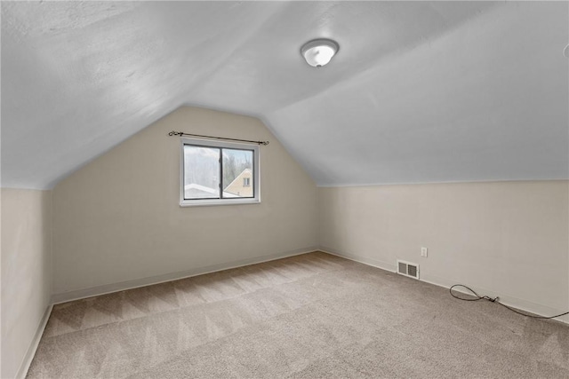 bonus room featuring visible vents, baseboards, vaulted ceiling, and carpet floors
