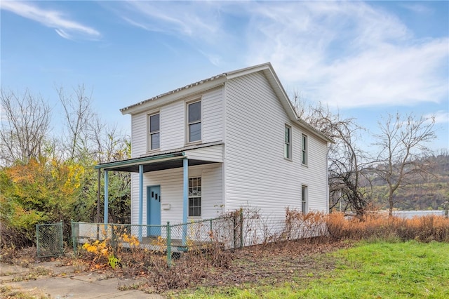 view of front facade with covered porch and a fenced front yard