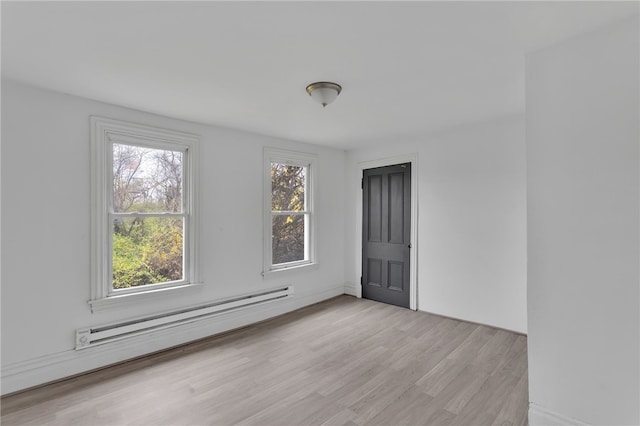 unfurnished room with light wood-style flooring, plenty of natural light, and baseboard heating