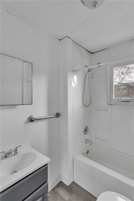 bathroom with  shower combination, vanity, toilet, and wood finished floors