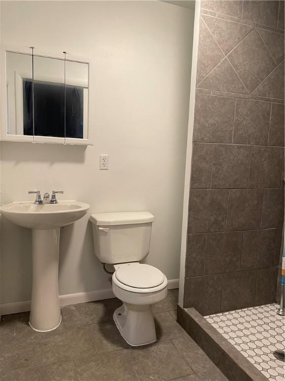 full bath featuring a shower stall, tile patterned floors, baseboards, and toilet