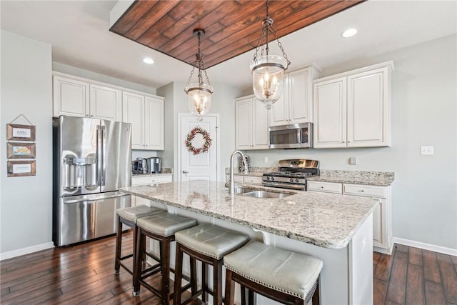 kitchen featuring a sink, baseboards, dark wood-type flooring, and stainless steel appliances