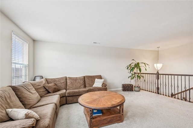 living room featuring light carpet, visible vents, and baseboards
