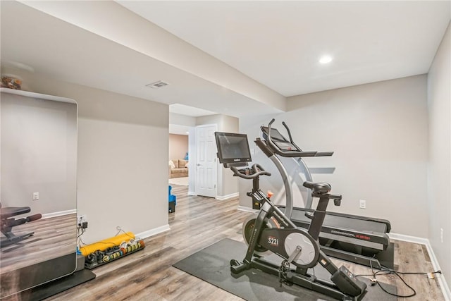 workout room with visible vents, baseboards, and wood finished floors