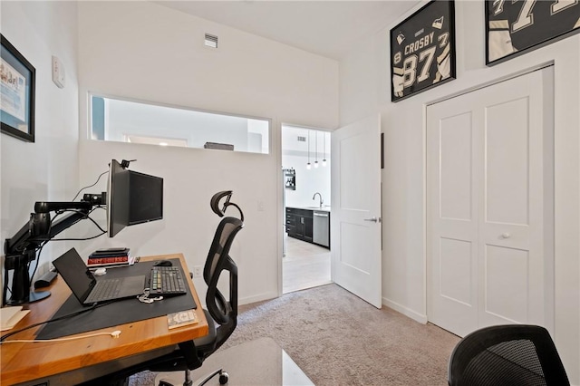home office featuring a sink, visible vents, baseboards, and carpet flooring