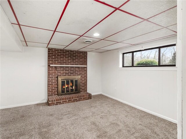 below grade area with a fireplace, a drop ceiling, and carpet floors