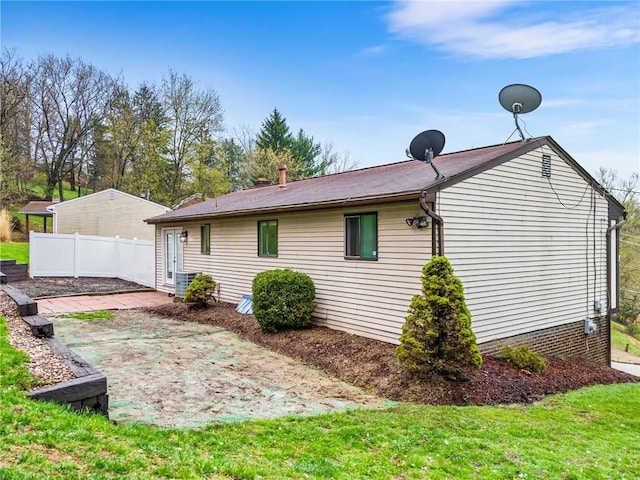rear view of property with cooling unit and fence
