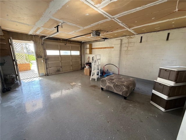 garage featuring a garage door opener and concrete block wall