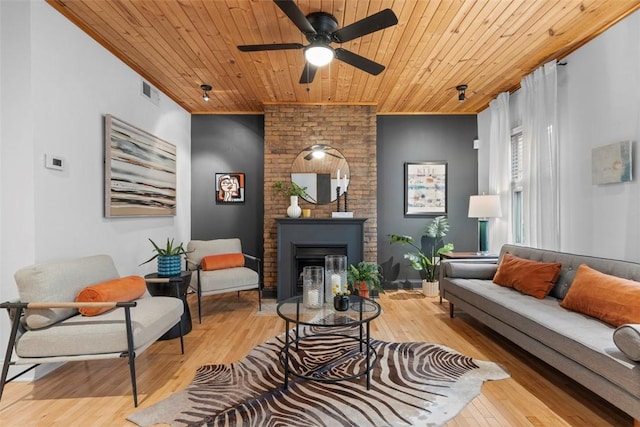 living room featuring a fireplace, wooden ceiling, a ceiling fan, and wood finished floors