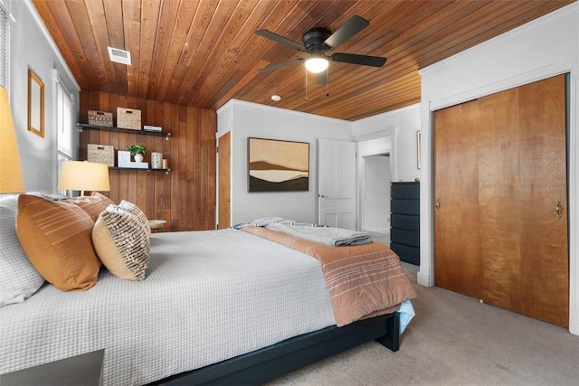carpeted bedroom featuring a closet, visible vents, and wood ceiling