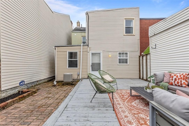 rear view of house with outdoor lounge area and a wooden deck
