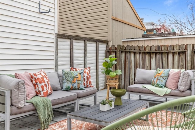 wooden terrace with outdoor lounge area and fence