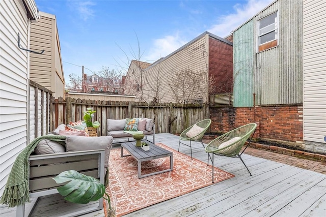 wooden deck with a fenced backyard and outdoor lounge area