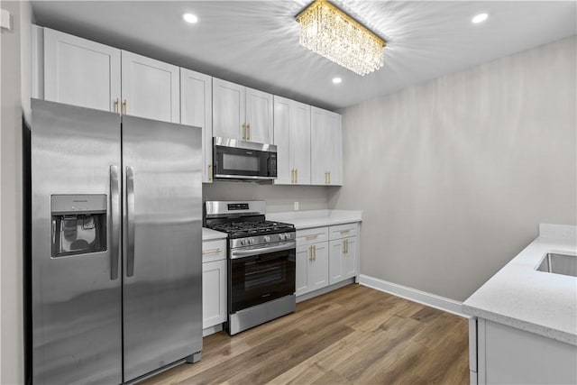 830 Adelaide St, Schenley Heights, PA 15219 - kitchen featuring a notable chandelier, white cabinetry, light wood finished floors, recessed lighting, and stainless steel appliances