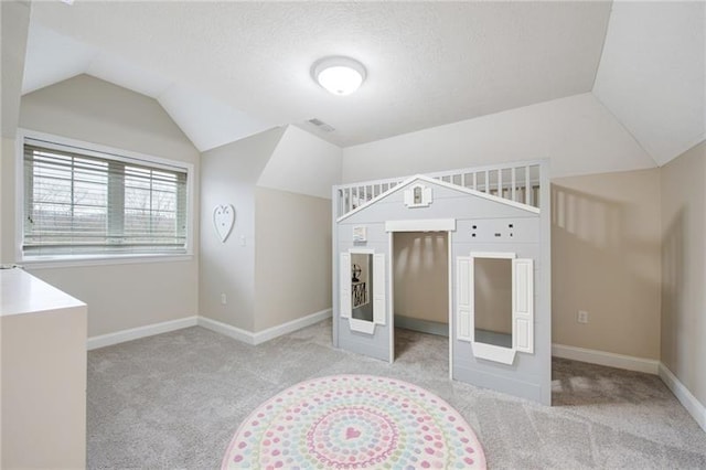 unfurnished bedroom featuring carpet floors, baseboards, and vaulted ceiling
