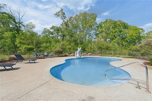 view of swimming pool featuring a fenced in pool, a patio, a water slide, and fence