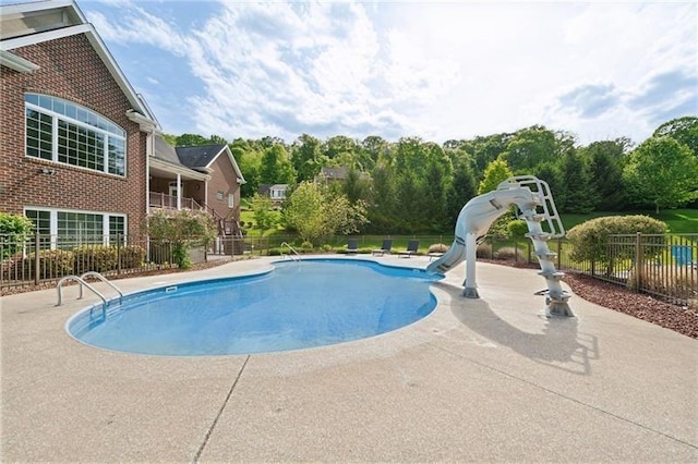 view of swimming pool with a fenced in pool, a patio, a water slide, and fence
