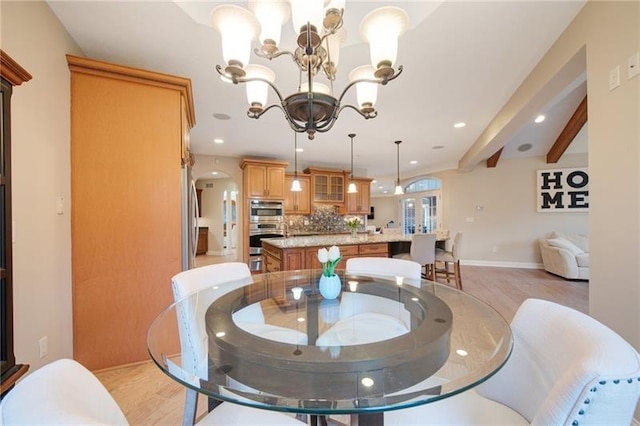 dining area with recessed lighting, light wood-style flooring, beamed ceiling, and an inviting chandelier