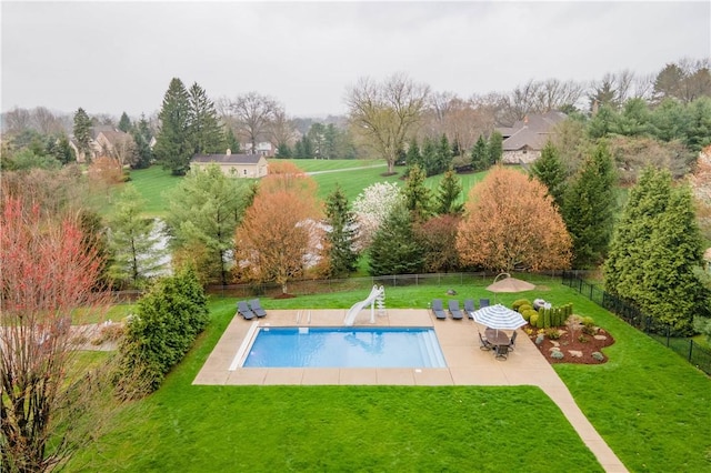 view of swimming pool with a yard, a patio area, a water slide, and fence