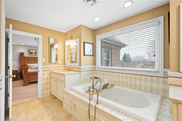 full bath featuring vanity, wainscoting, and a healthy amount of sunlight