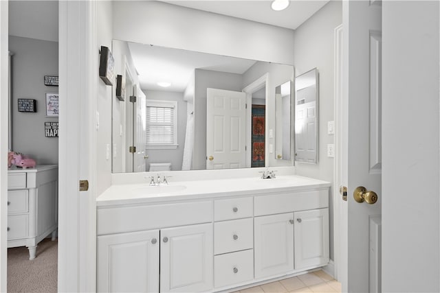 full bathroom with a sink, toilet, and double vanity