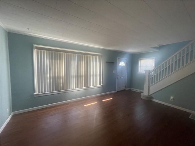 foyer featuring visible vents, baseboards, crown molding, wood finished floors, and stairs