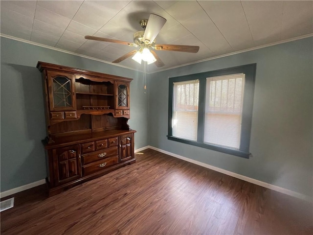 unfurnished room featuring a ceiling fan, crown molding, and dark wood-style floors