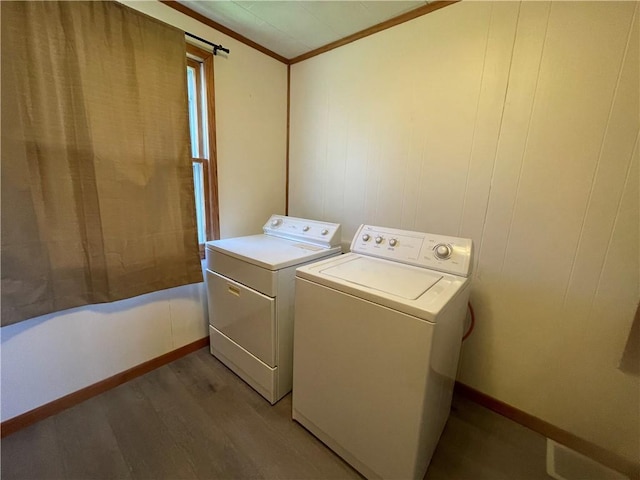 clothes washing area with light wood-style floors, laundry area, crown molding, baseboards, and washer and clothes dryer
