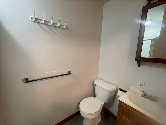 half bath featuring vanity, baseboards, and toilet