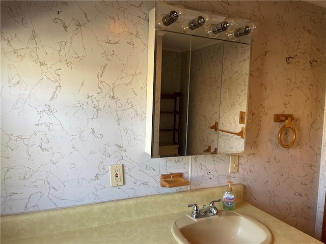 bathroom with a sink and wallpapered walls