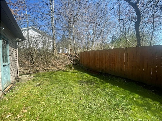view of yard with fence and stairway