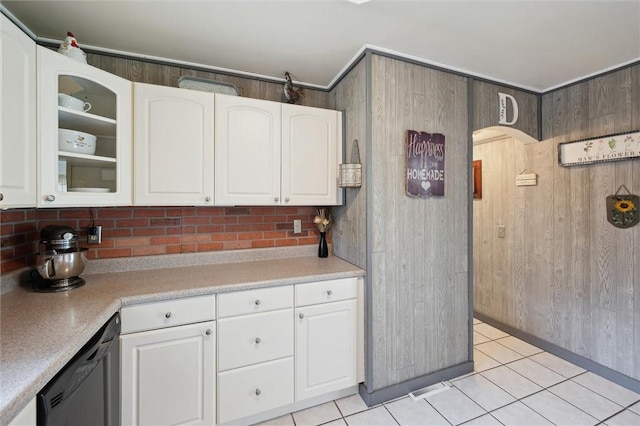 kitchen with light tile patterned floors, glass insert cabinets, black dishwasher, light countertops, and white cabinetry