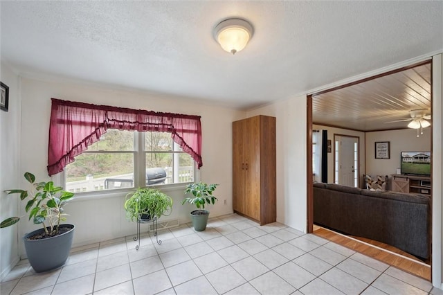 entrance foyer featuring ceiling fan, a textured ceiling, and light tile patterned flooring