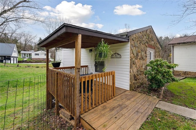 wooden terrace with a yard and fence