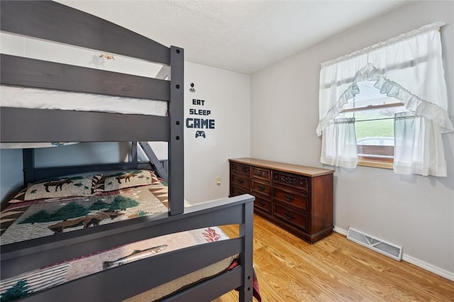 bedroom featuring light wood-style floors, baseboards, and visible vents