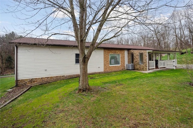 back of house featuring cooling unit and a lawn