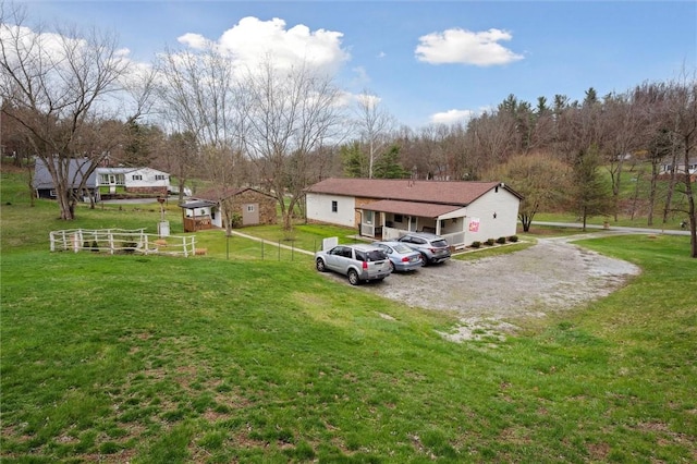 exterior space with driveway, fence, and a front lawn
