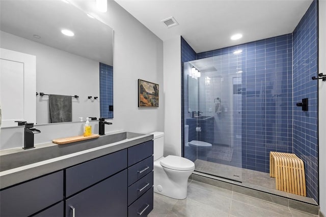 full bathroom featuring vanity, a stall shower, tile patterned flooring, toilet, and visible vents
