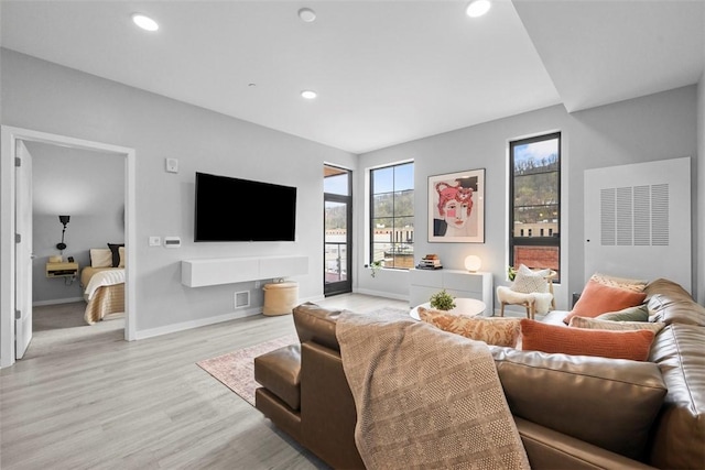 living area with baseboards, recessed lighting, and light wood-style floors