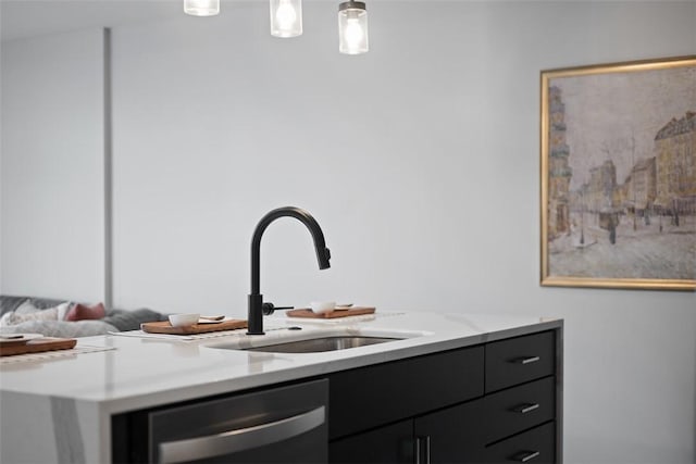 interior space featuring stainless steel dishwasher, a sink, and hanging light fixtures