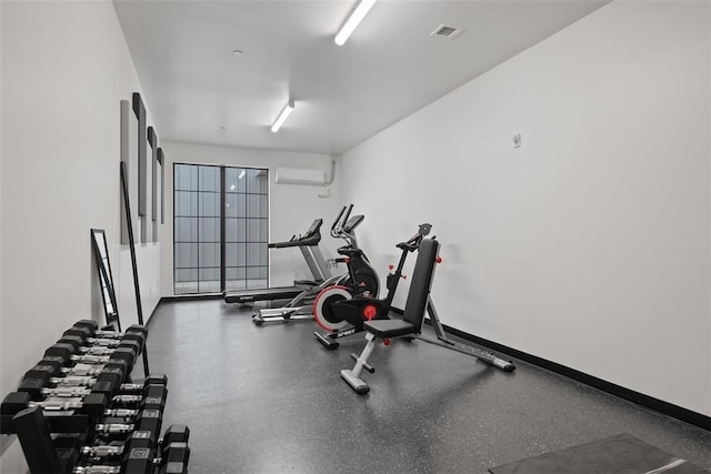 exercise room with a wall mounted AC, baseboards, and visible vents