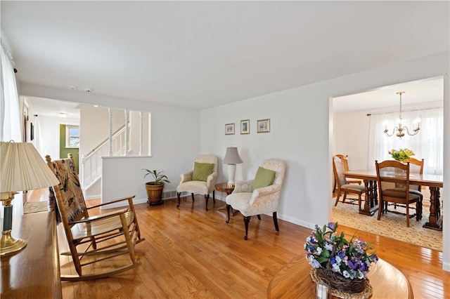 1171 Fox Terrier Dr, Bethel Park, PA 15102 - living area featuring stairs, a notable chandelier, light wood-style floors, and baseboards