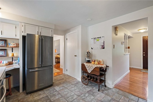 1171 Fox Terrier Dr, Bethel Park, PA 15102 - kitchen featuring white cabinets, baseboards, light countertops, freestanding refrigerator, and stone finish floor