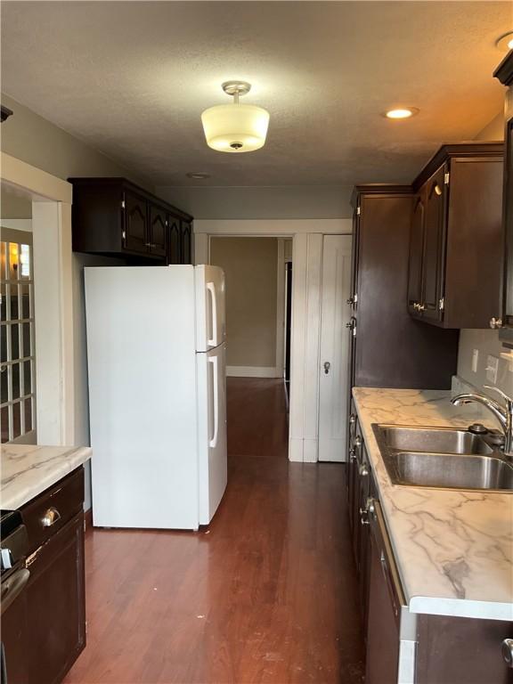 913 Russellwood Ave, Mckees Rocks, PA 15136 - kitchen featuring dark wood-type flooring, freestanding refrigerator, a sink, and dark brown cabinetry